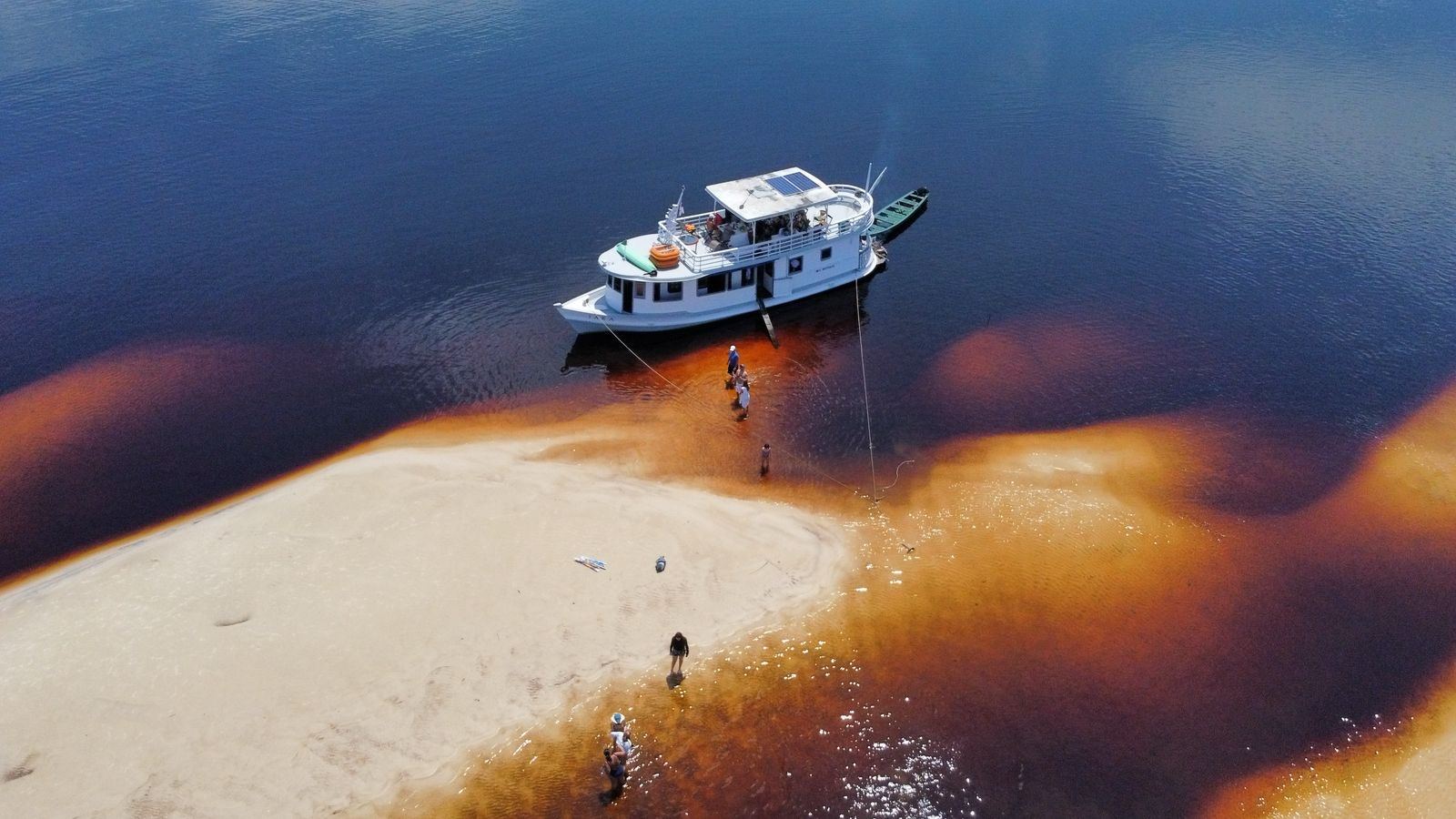 Barco ancorado ao lado de um banco de areia no rio, visto do alto