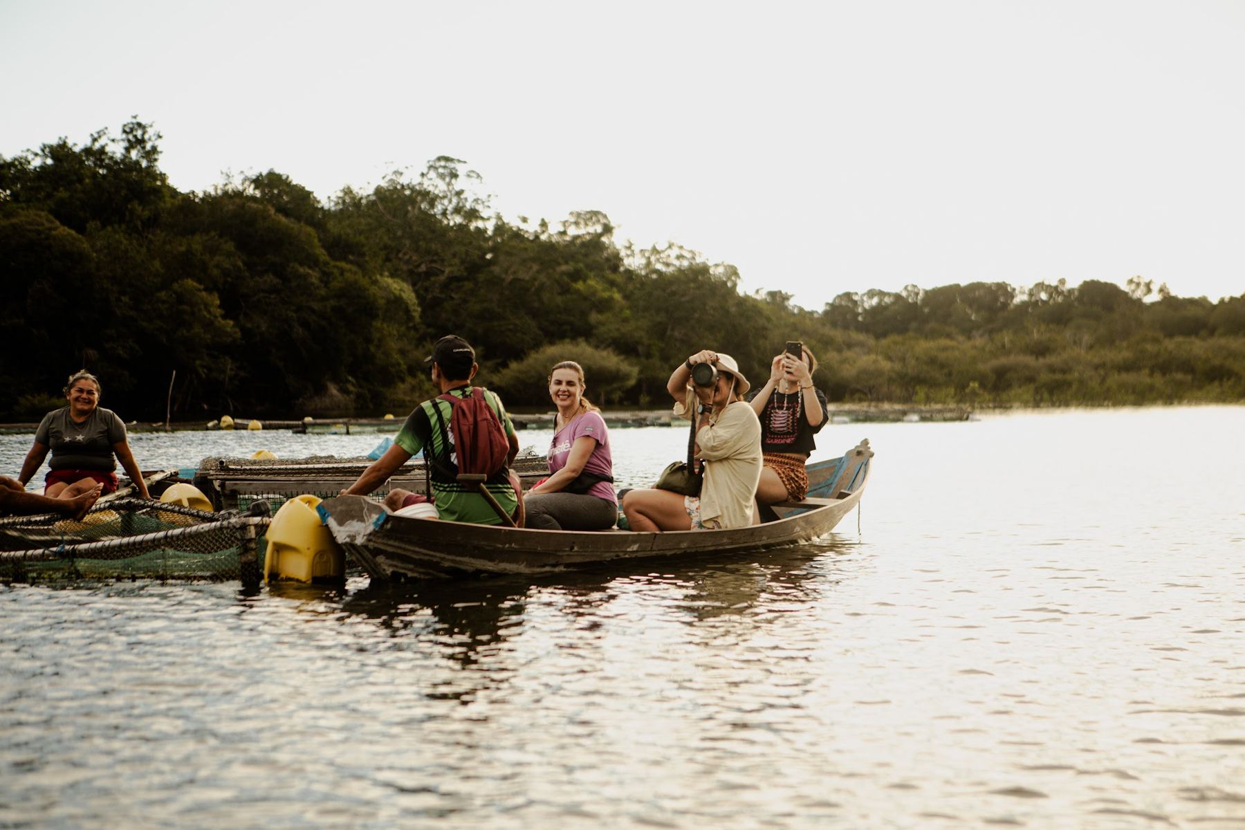 Canoas com visitantes navegando num rio cercado de floresta